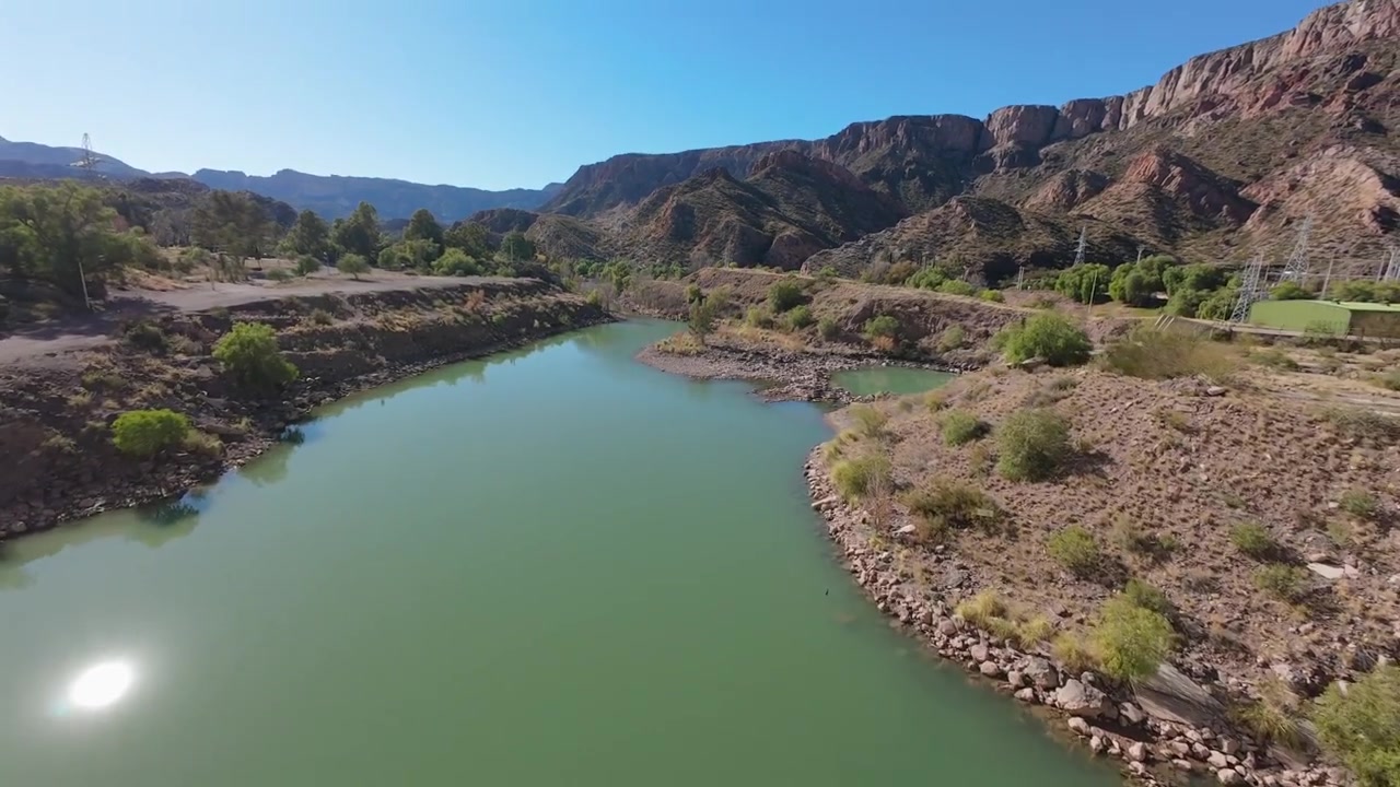 Mergulho emocionante de drone FPV sobre a borda da imensa Barragem Valle Grande no Cânion do Atuel, Mendoza, Argentina, revelando o rio esmeralda abaixo.