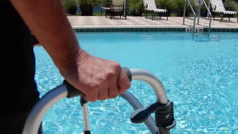 hombre discapacitado con su andador junto a una piscina