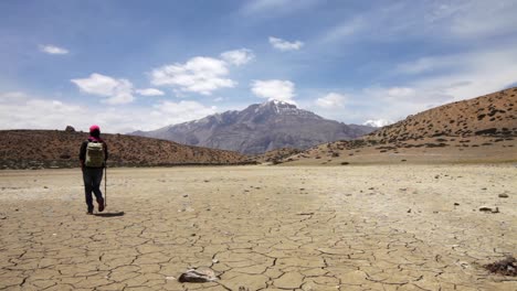 Woman-traveler-walks-on-a-dry-mountain-lake