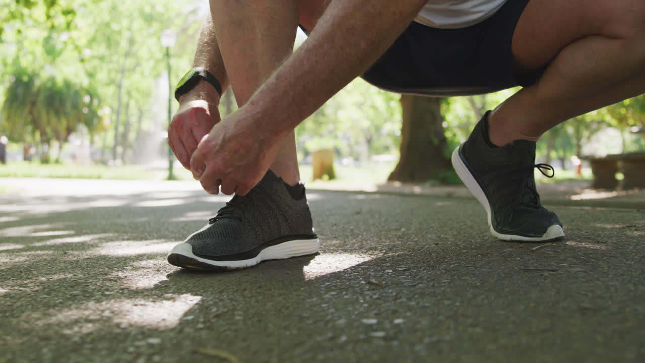 Parte inferiore di un uomo anziano che si allaccia le scarpe