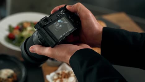 close-up of a male hand taking a picture on a mirrorless dish on the table