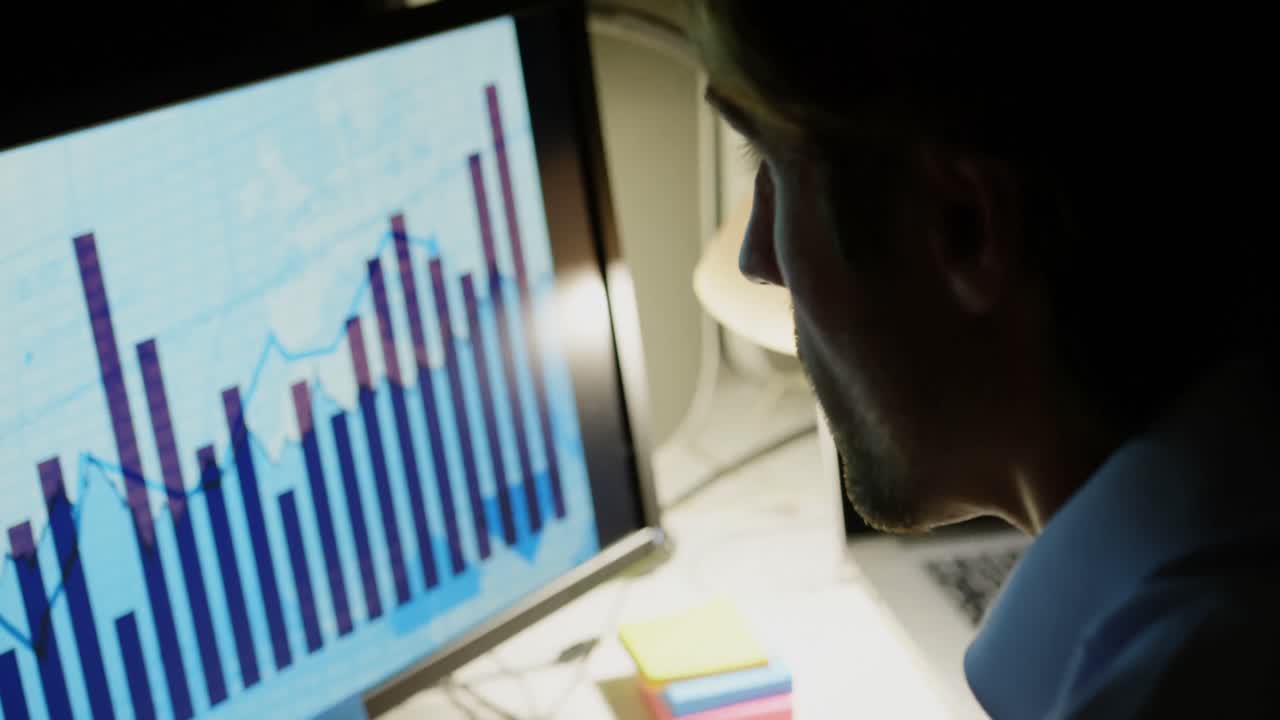 Side view of young Caucasian male executive working on computer at desk in modern office 4k