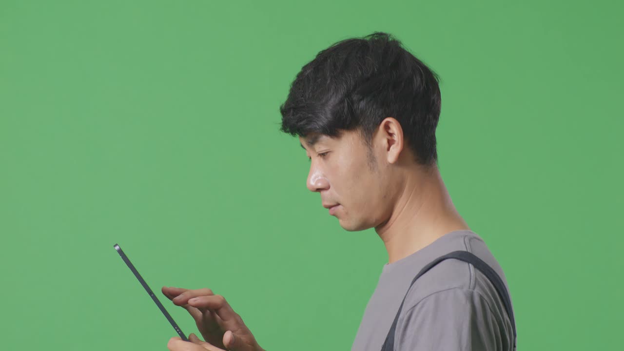 녹색 화면에서 태블릿을 사용하는 사람