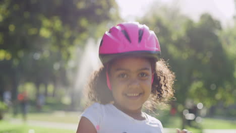 una niña alegre y emocionada con un casco rosa