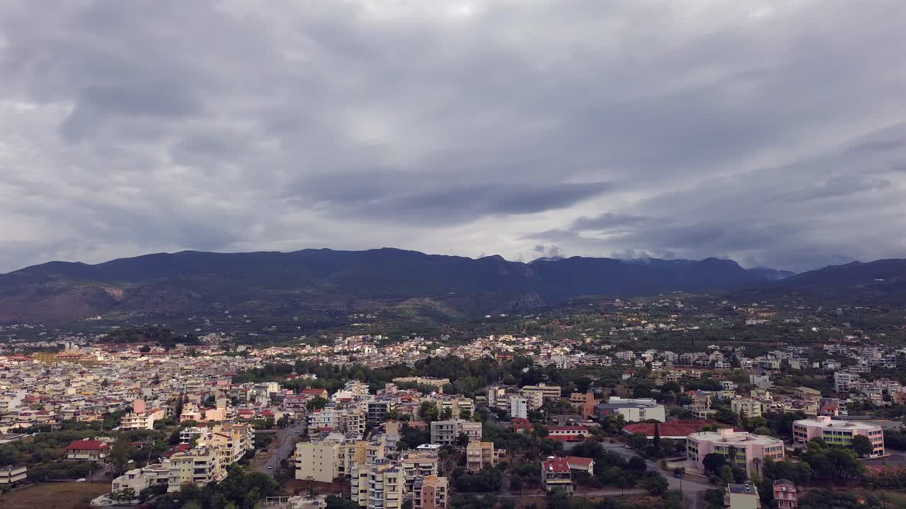 Aerial high angle view of northern suburbs of Kalamata city on an autumn day, cloud covered mountains on the background, right slide orbital drone movement 4K