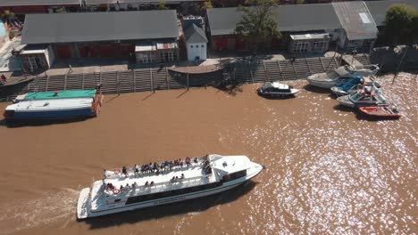 catamaran sailing through a waterway with some people aboard at tigre, buenos aires