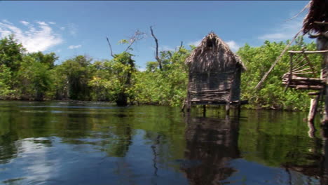 Casas-Con-Techo-De-Paja-Sobre-Pilotes-En-Un-área-De-Río-Tropical-1