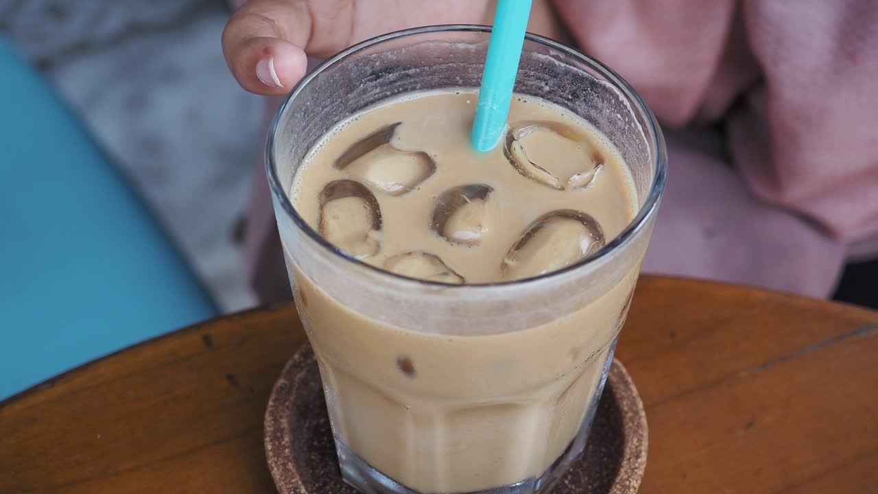 cerca de un vaso de café helado con una pajita