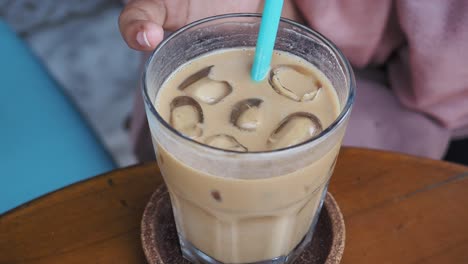 close up of a glass of iced coffee with a straw