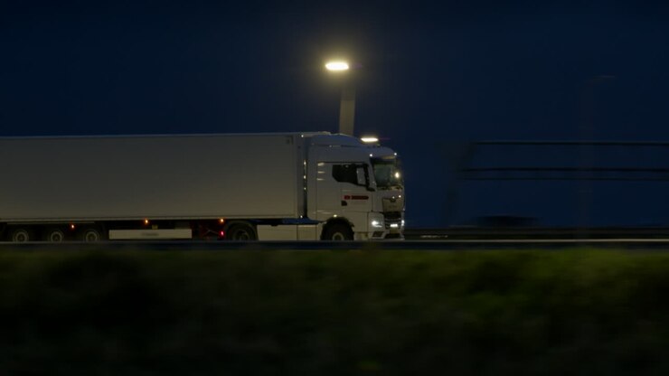 weißer lastwagen fährt nachts auf der autobahn