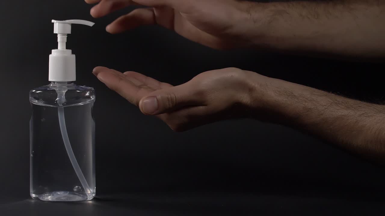 Hygiejne med antibakteriel håndspritgel på sort baggrund.