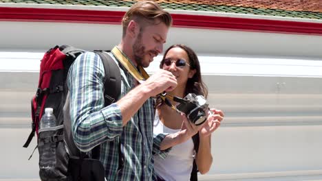 couple tourist looking at pictures in camera on holidays in thailand