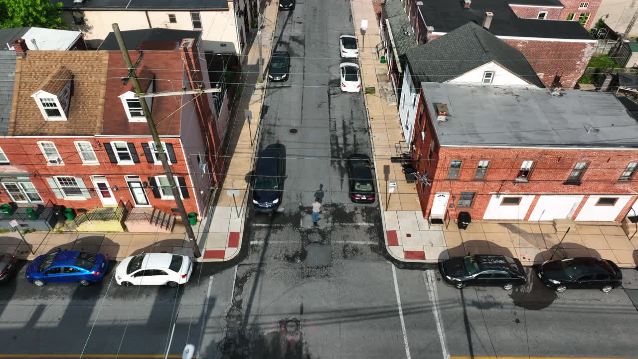 Aerial, top down tracking shot of man scooter in city. Electric scooter used as method of transportation on pleasant weather day in America.