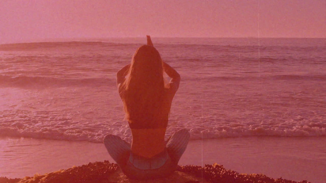 Praticare yoga in spiaggia, persona che medita al tramonto con animazione rilassante