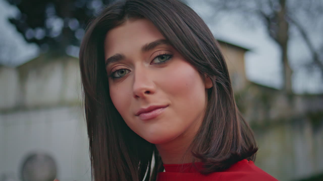 Romantic girl adjusting hairstyle at city portrait. Brunette lady looking camera