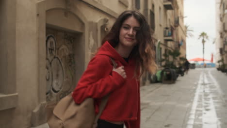 young girl smiling and looking at the camera in the street