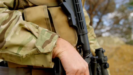 primer plano de un joven soldado militar caucásico entrenando con rifle en los campos durante el entrenamiento militar 4k
