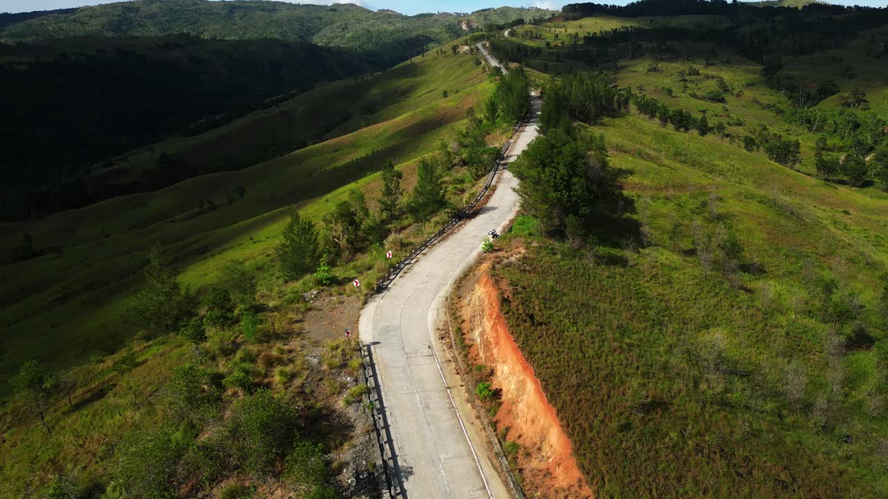 Dron captura Daang Katutubo mientras cruza ríos escénicos, rodeado de exuberantes campos y paisajes rurales en Pangasinán. Ideal para proyectos de viajes, naturaleza y aventura