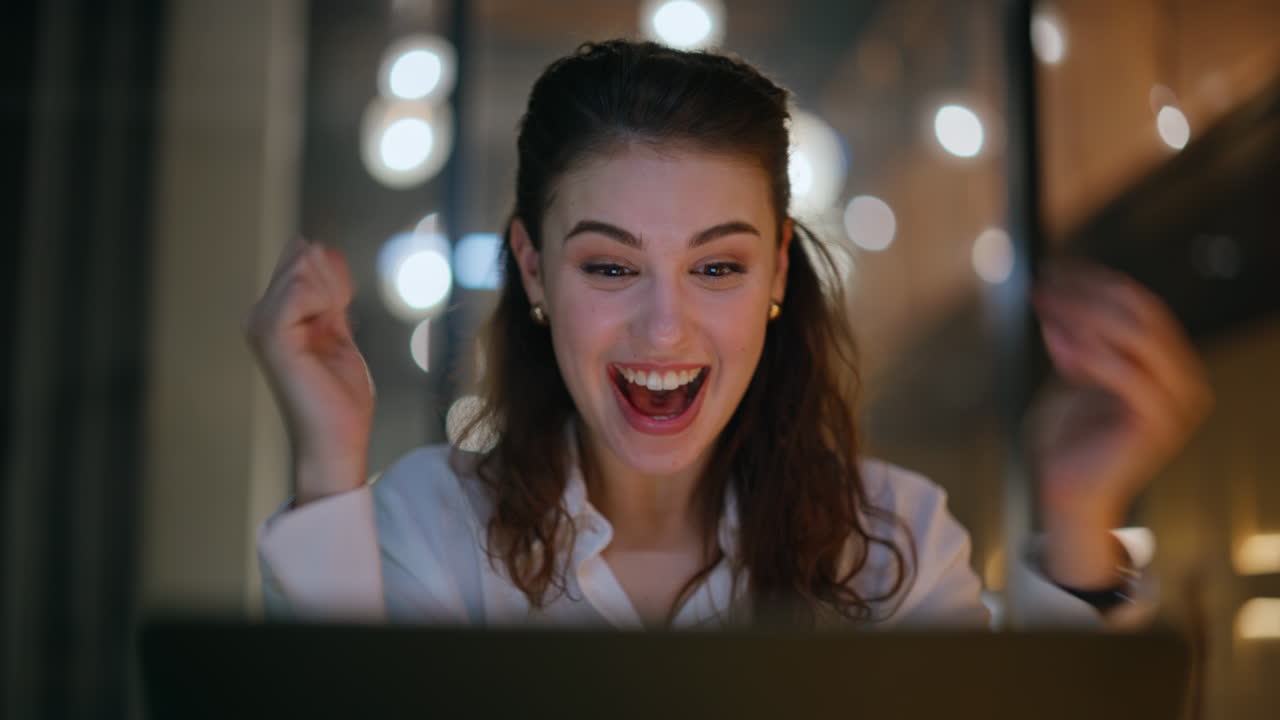 Amazed woman enjoy successful startup looking laptop at night office closeup