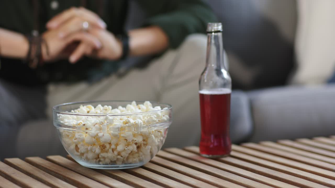 L'autofocus sta rilevando la sfocatura e modificando la messa a fuoco sui popcorn e sulla bevanda rossa sul tavolo per maggiore nitidezza