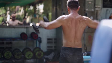 man working out with dumbbells in an outdoor gym