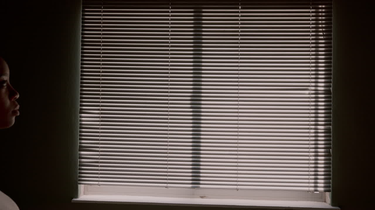 Woman opening curtain, window blinds
