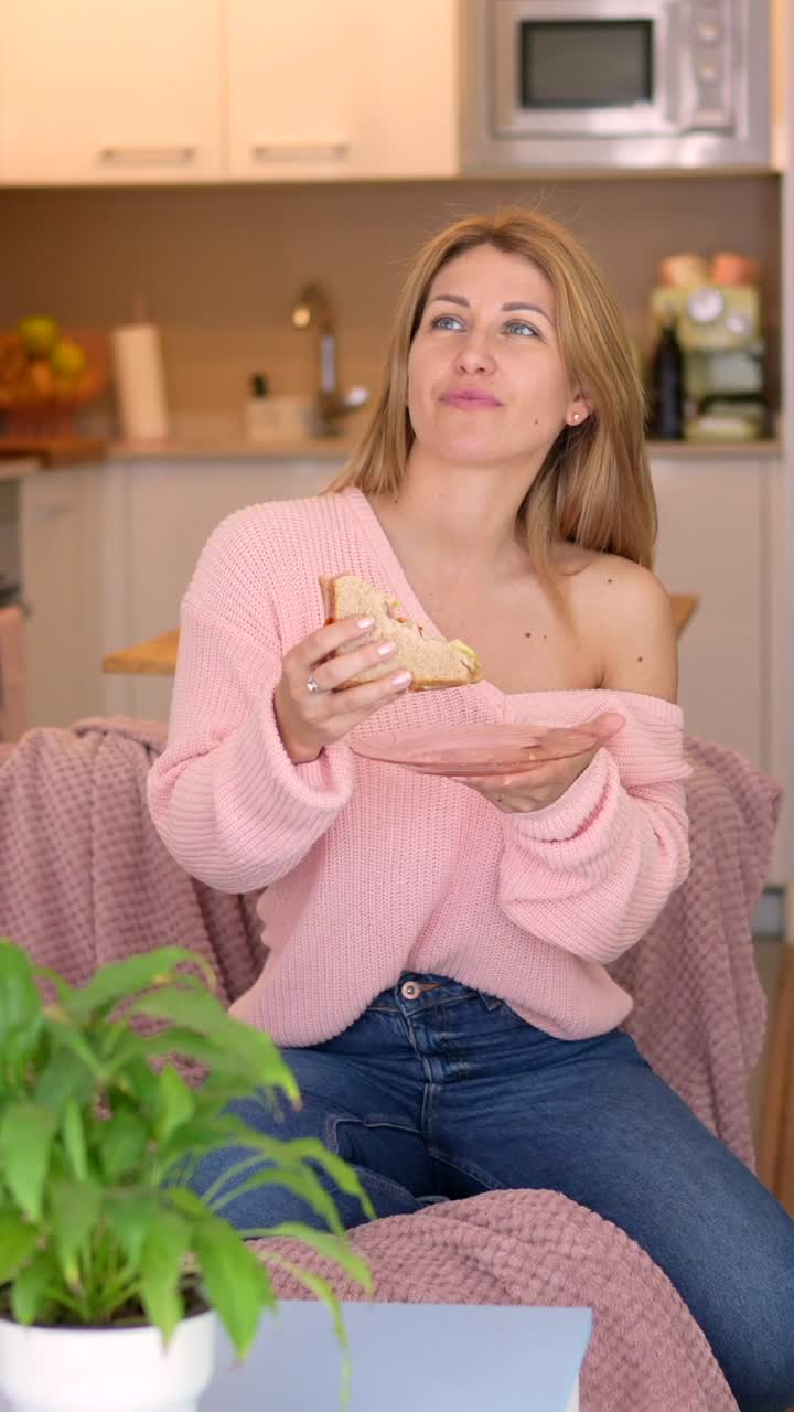 Woman eating sandwich indoors