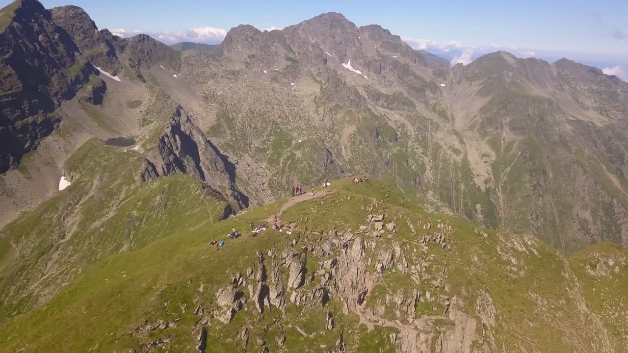 등산객과 백패커가 정상에 있는 외딴 산 정상 위를 공전하는 드론