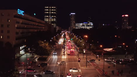 Forwards-fly-above-busy-street-in-night-city.-Traffic-jam-during-evening-rush-hour.-Long-queue-of-cars.-Warsaw,-Poland