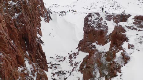 snowy mountain cliffs with hikers