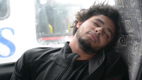 young african american black man sleeps on bus chair sitting down close up