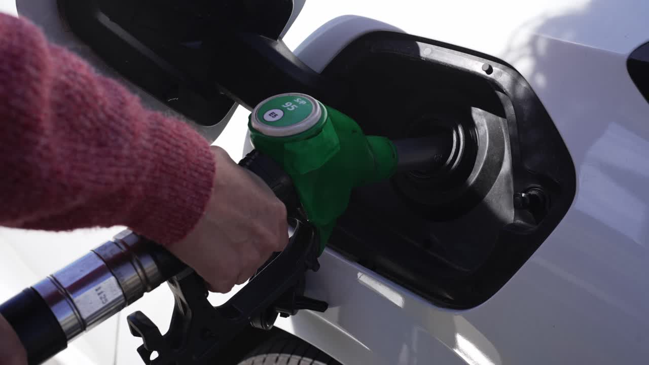 Close-up of Hand Refueling White Car at Gas Station