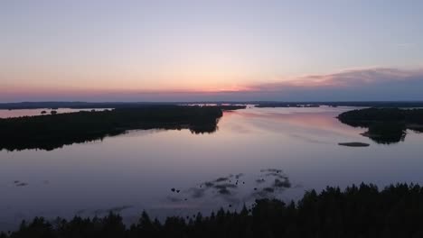 Aerial-of-a-lake-and-forest-at-dawn-in-Finland