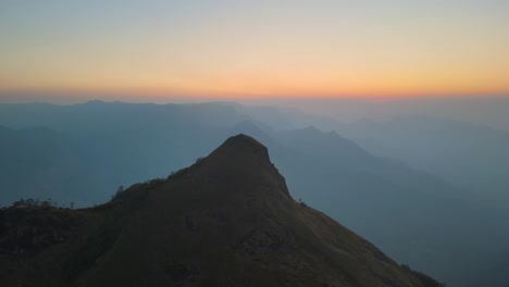 aerial drone shot of kolukkumalai range, where morning sun meets the misty mountains