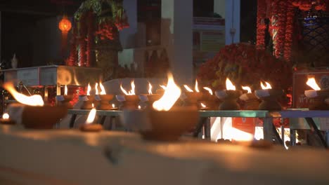 countless traditional and holy candles burning infront of buddhist temple at night time during loy krathong festival in chiang mai, thailand