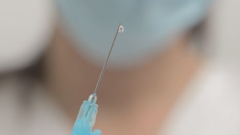 close-up of drops coming out of a syringe needle