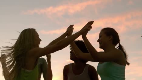 happy sporty women cheering against sunset