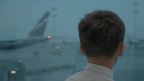 kid likes to watch planes when waiting for the flight