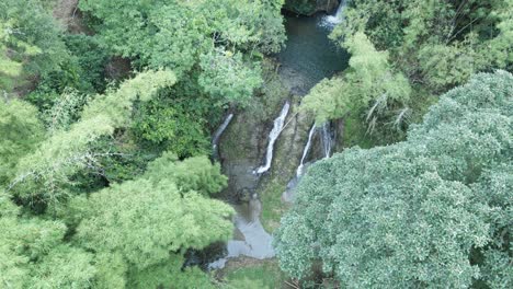 Vista-Ascendente-De-Drones-De-Una-Cascada-En-Lo-Profundo-De-La-Jungla-En-Cámara-Lenta