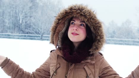 smiling woman in fur jacket enjoying the snowfall