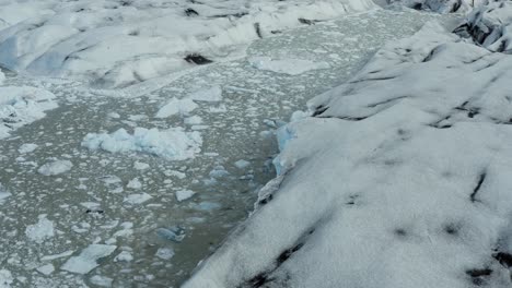 Pedacitos-De-Bergy-Flotan-En-El-Lago-Glacial-Del-Glaciar-Vatnajokull,-Islandia---Antena