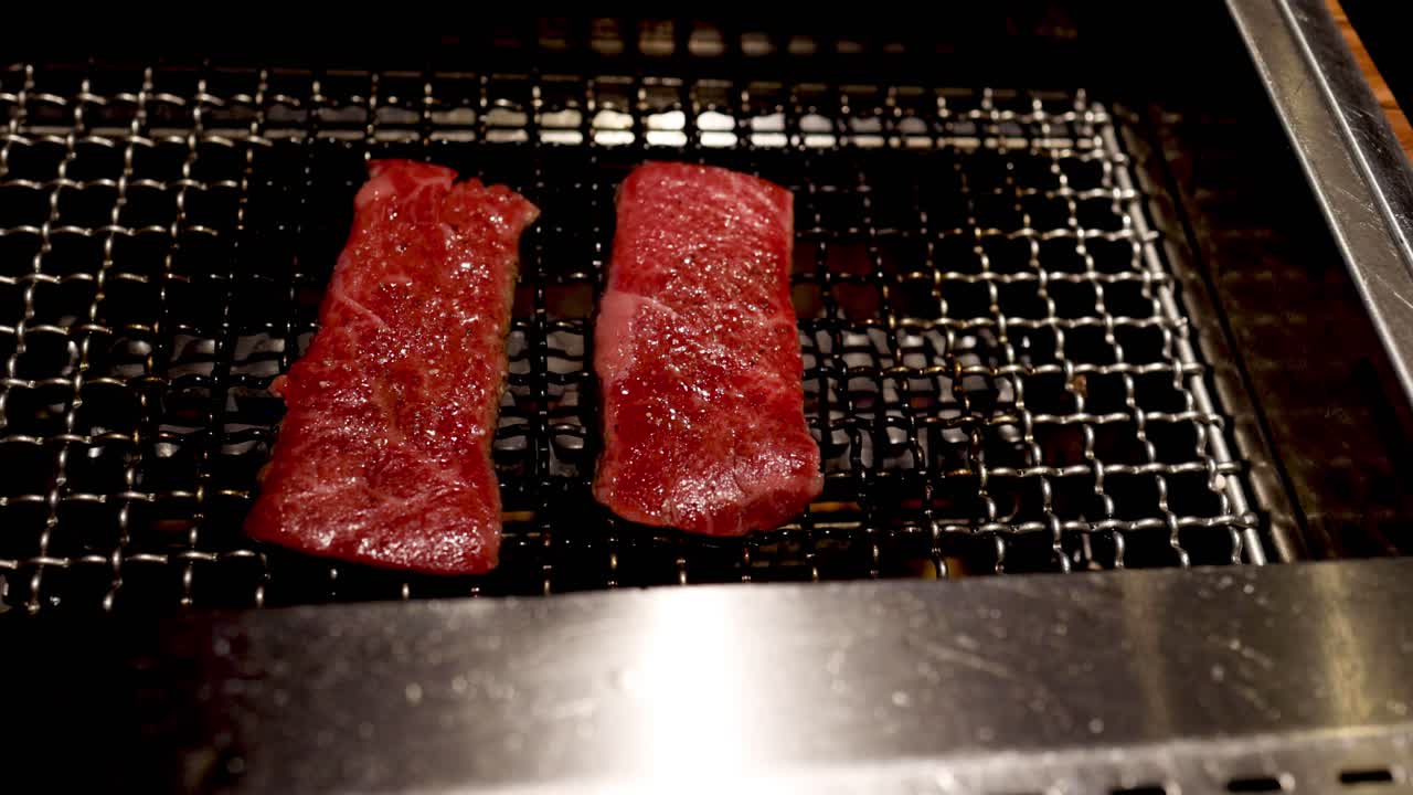 Succulent steaks cooking on a grill grate.