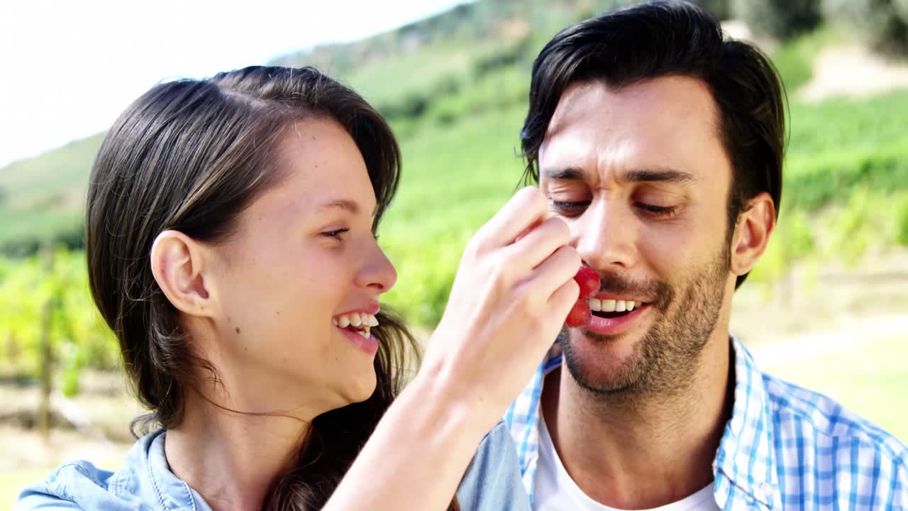 농장 에 있는 남자 에게 포도 를 먹이는 여자