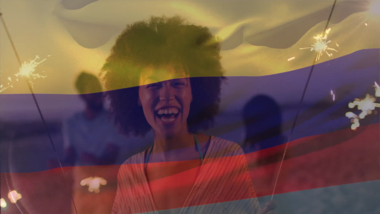 Holding sparklers over Colombian flag colors, woman celebrating joyfully at sunset