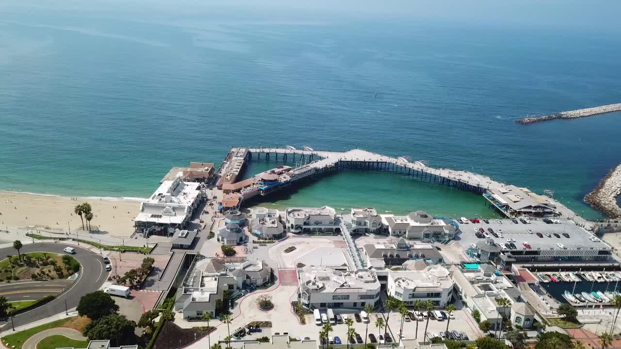 Aerial top down of Redondo Beach with waterfront buildings and parking boats at port. Sunny Summer day with clear ocean water in Los Angeles, California