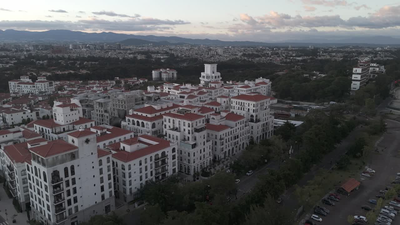 Panoramic view of Cayalá, an upscale urban development in Guatemala City, featuring Mediterranean-style white buildings with red roofs.