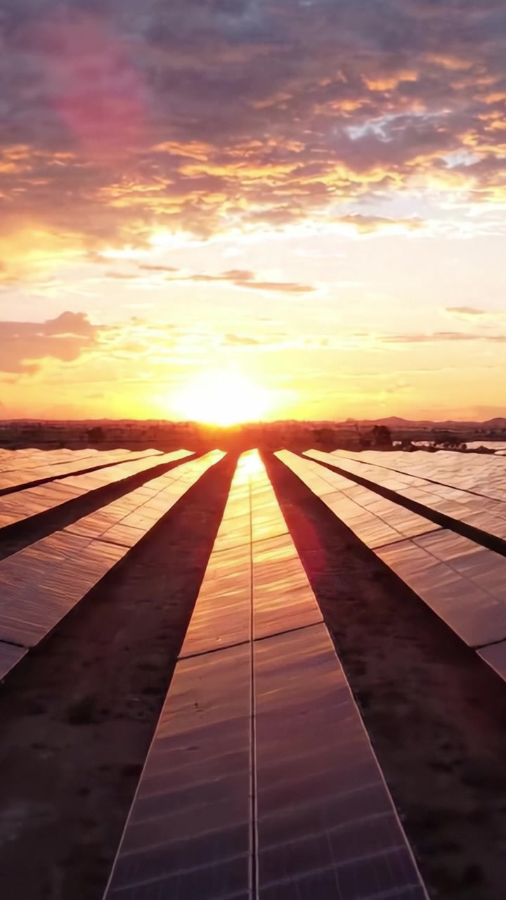 Fængslende solnedgang over solpaneler: En betagende udsigt over infrastruktur for vedvarende energi, mens solen dykker under horisonten og bader alt i gyldent lys.