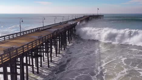 aerial over huge waves rolling in over a california pier in ventura california during a big winter storm suggests global warming and sea level rise or tsunami 5