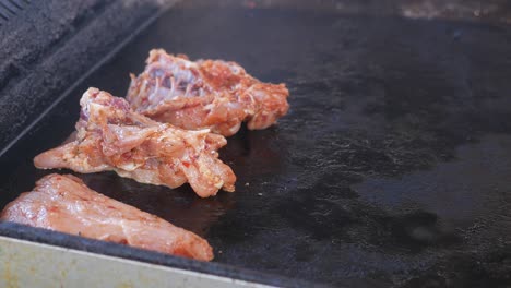 grilling marinated chicken on a flat top griddle