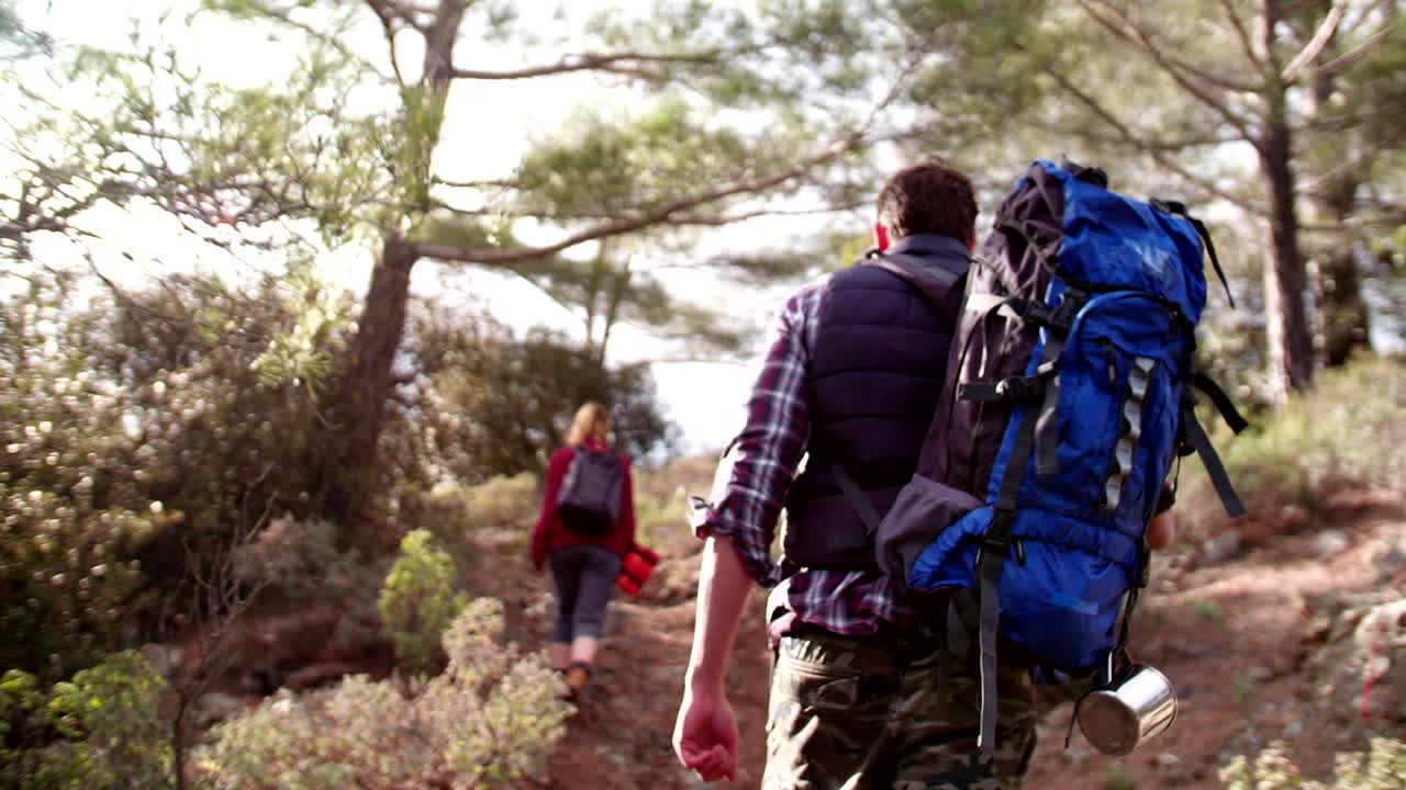 Group of hikers with backpacks walking up a mountain